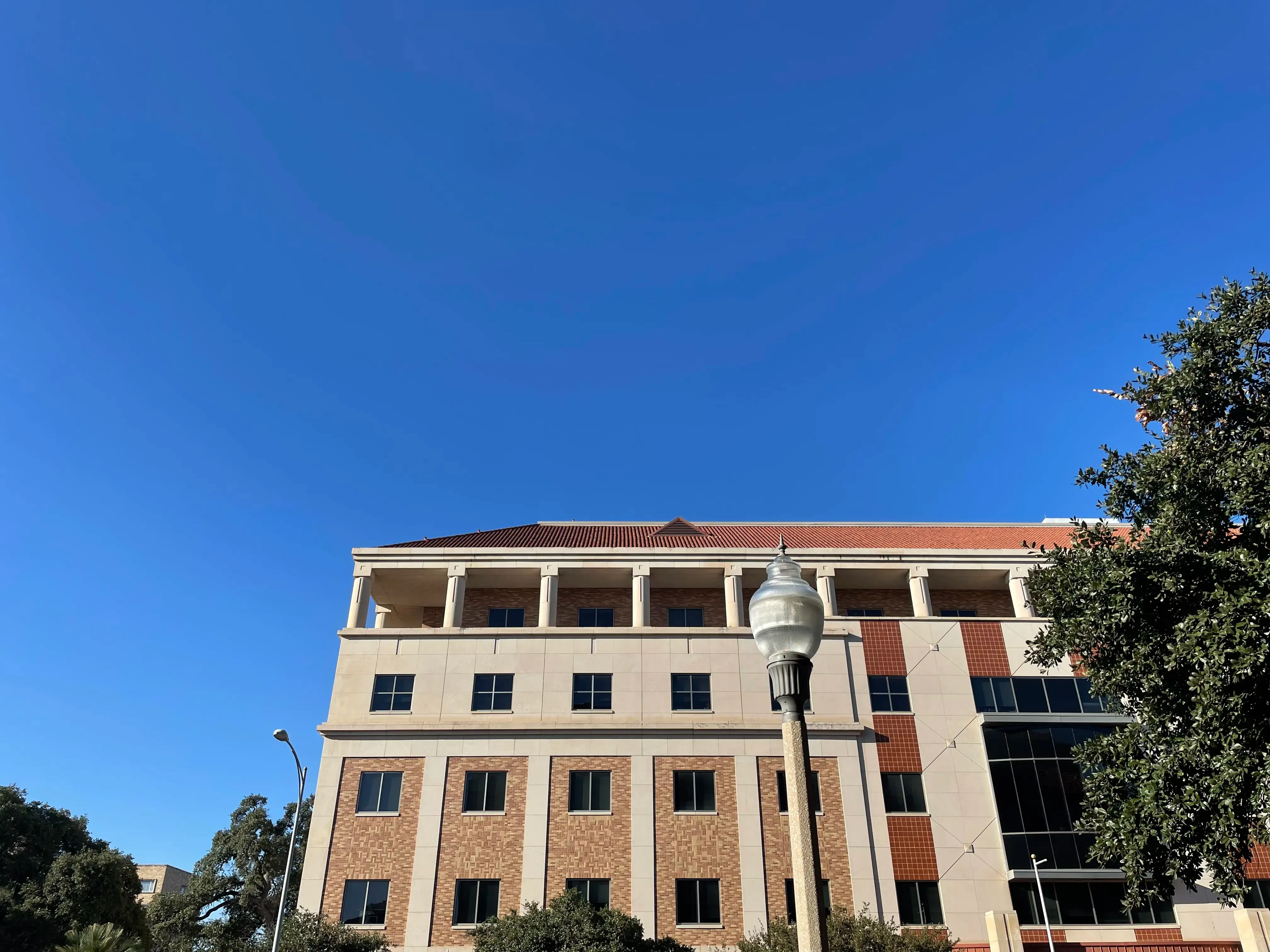Blue sky with the UT Student Services Building in the bottom of the frame.