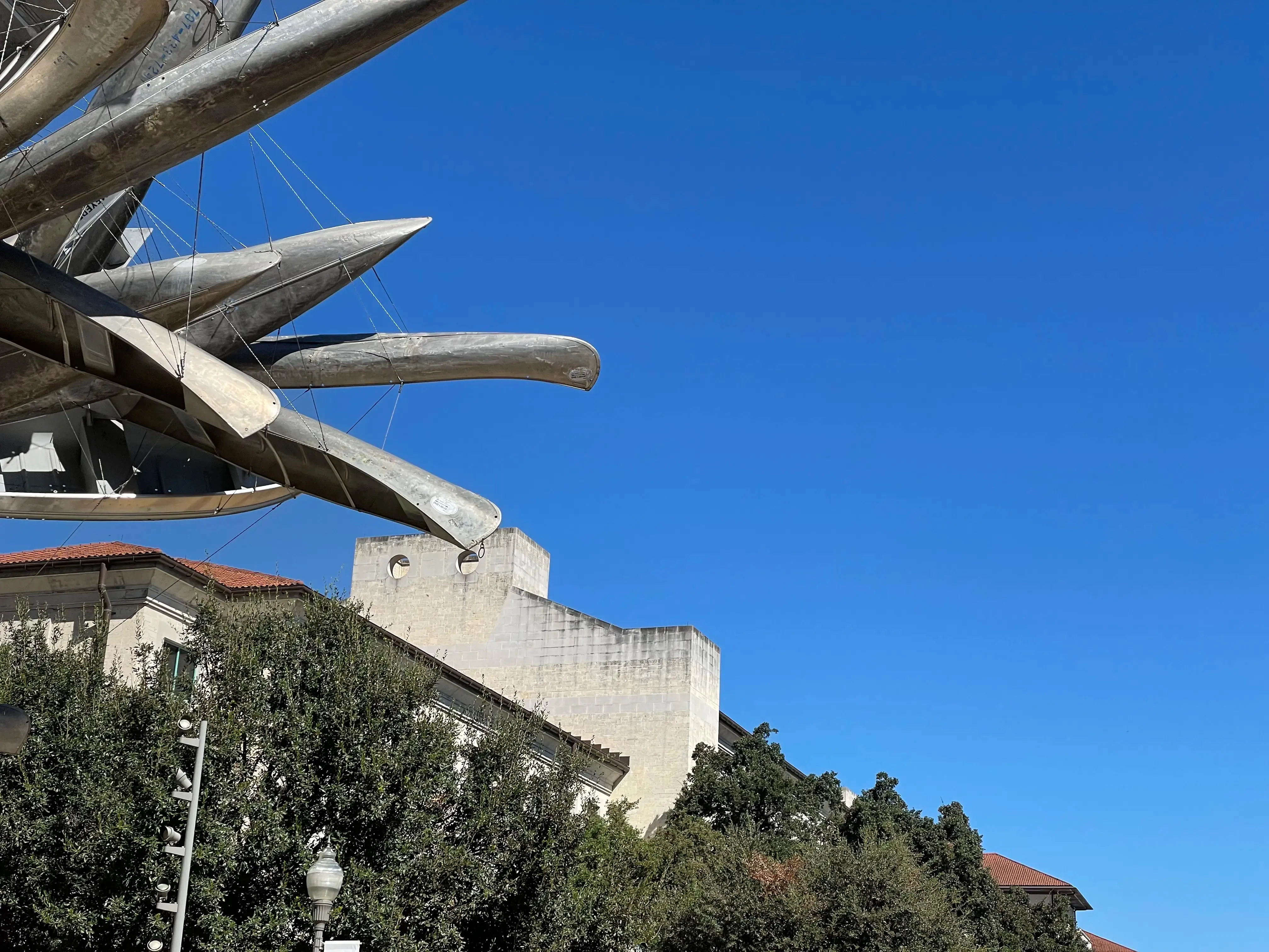 Blue sky with the UT MBB in the bottom of the frame and UT canoe sculpture of to the left.