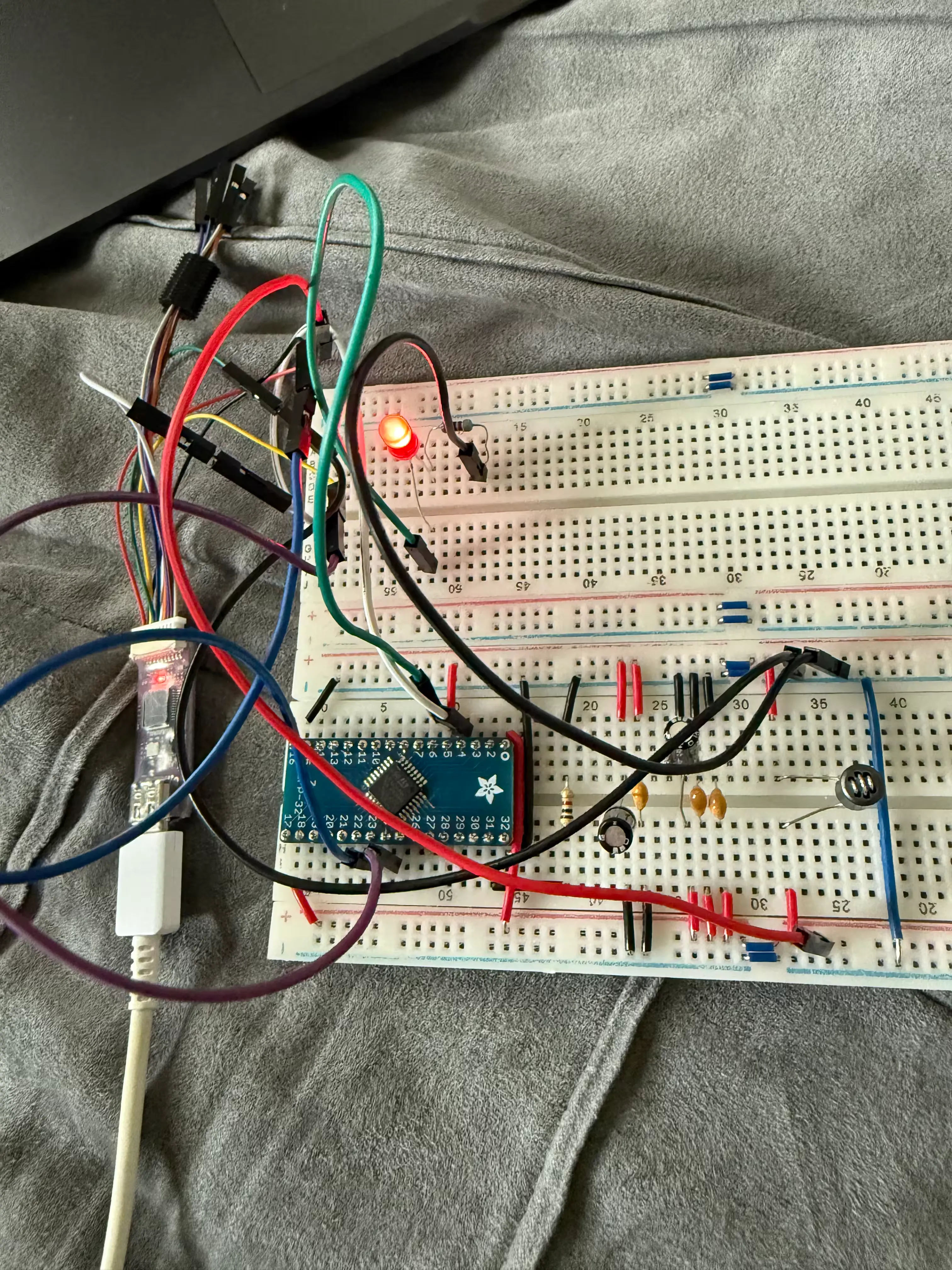 Picture of a breadboard circuit for the STM32L010K8. A red LED is on due to
the circuit running a "blink" program.